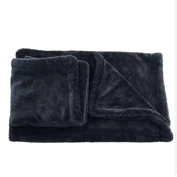 Folded dark gray drying towel on a white background