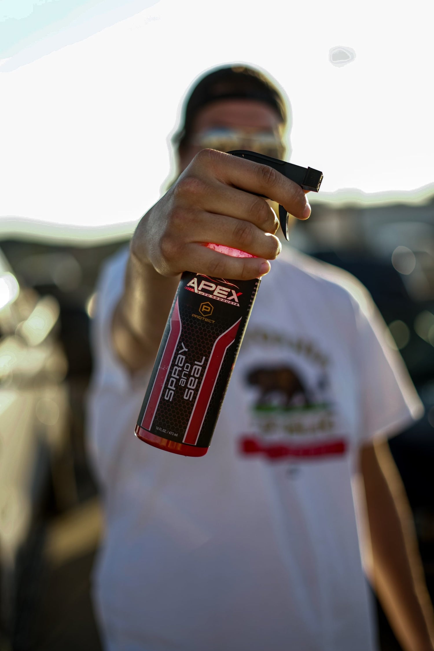 APEX Auto Products Man holding red Apex Spray and Seal product
